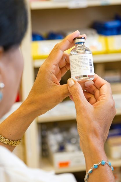 A clinical pharmacist inspects medication